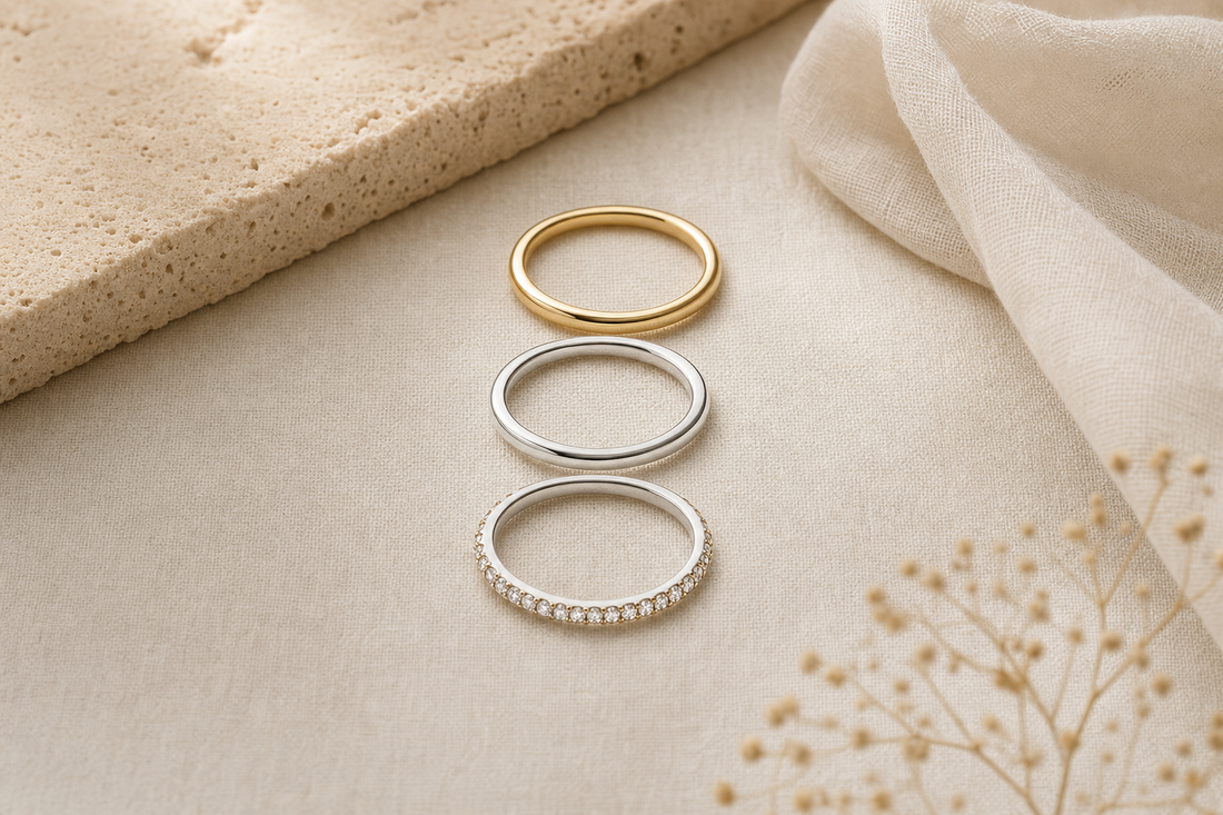 Three slim stacking rings in gold and silver on linen