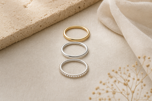 Three slim stacking rings in gold and silver on linen