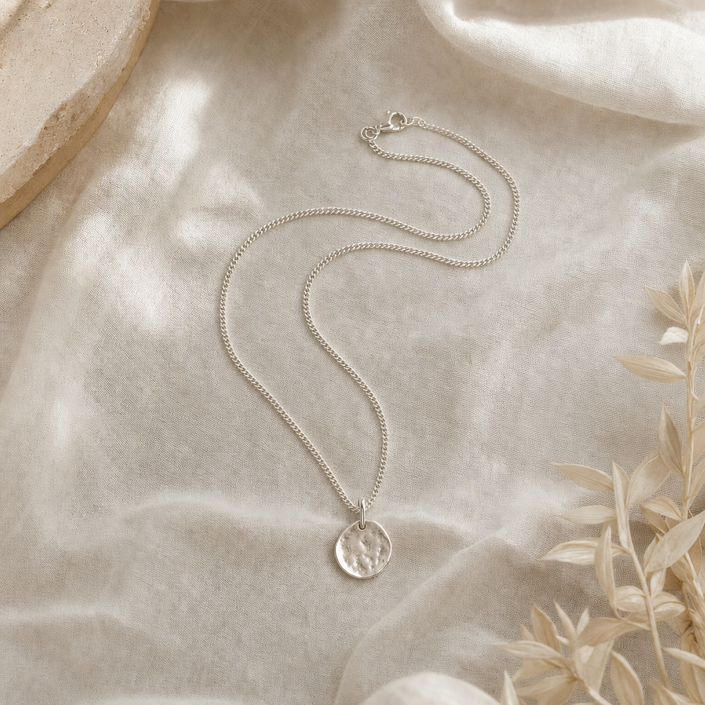 Sterling silver curb-chain pendant necklace on linen