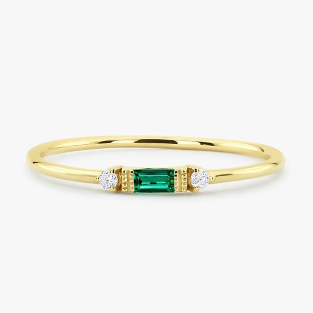 Yellow gold ring with emerald baguette and diamond accents